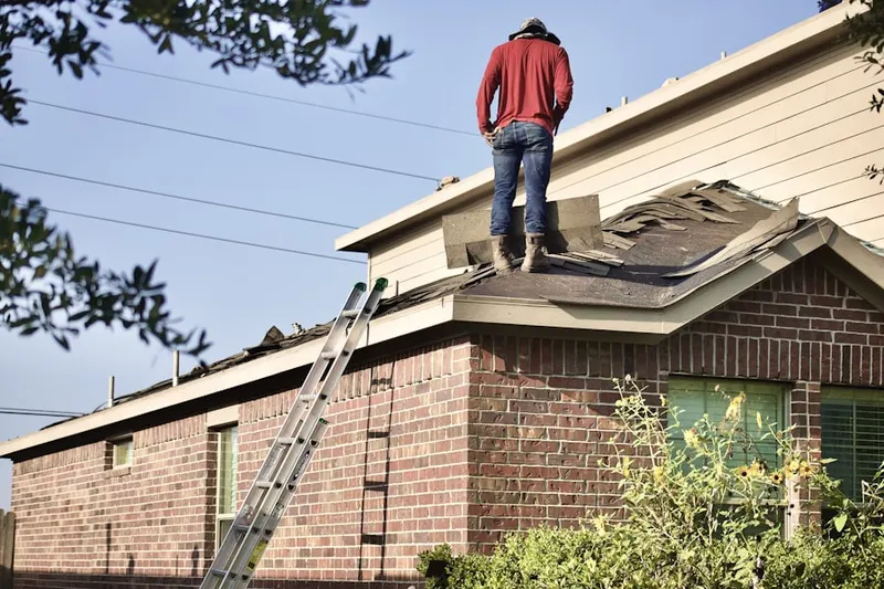Professional roofer working on a residential roof in Running Brook Park